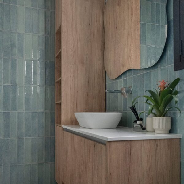 nicosia migliore no.10, newly built house Shower area clad in bold blue terrazzo tiles with yellow aggregate highlights, frameless glass screen, and black ceiling‑mounted rainfall showerhead