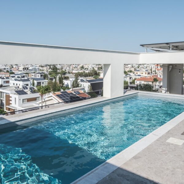 “After – Rooftop garden with natural stone paving and seating area” “After – Timber pergola shading outdoor lounge on roof terrace” “After – Built-in planter beds with greenery in rooftop design” “After – Evening rooftop garden with ambient outdoor lighting” “After – Detail of stone paving and glass railing overlooking Nicosia
