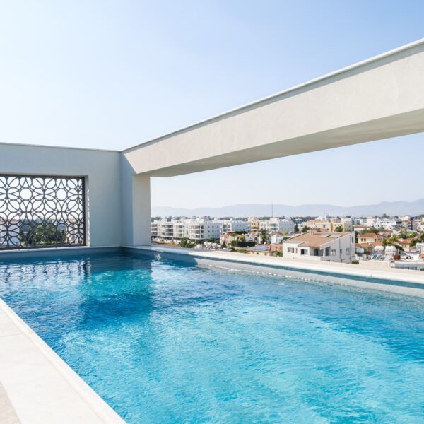 “After – Rooftop garden with natural stone paving and seating area” “After – Timber pergola shading outdoor lounge on roof terrace” “After – Built-in planter beds with greenery in rooftop design” “After – Evening rooftop garden with ambient outdoor lighting” “After – Detail of stone paving and glass railing overlooking Nicosia