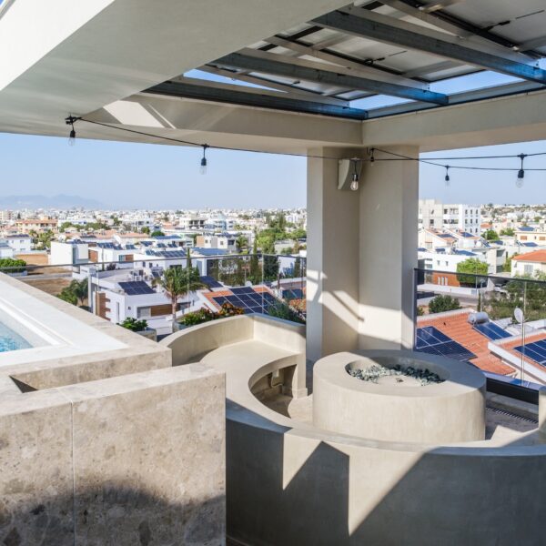 “After – Rooftop garden with natural stone paving and seating area” “After – Timber pergola shading outdoor lounge on roof terrace” “After – Built-in planter beds with greenery in rooftop design” “After – Evening rooftop garden with ambient outdoor lighting” “After – Detail of stone paving and glass railing overlooking Nicosia
