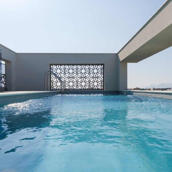 “After – Rooftop garden with natural stone paving and seating area” “After – Timber pergola shading outdoor lounge on roof terrace” “After – Built-in planter beds with greenery in rooftop design” “After – Evening rooftop garden with ambient outdoor lighting” “After – Detail of stone paving and glass railing overlooking Nicosia